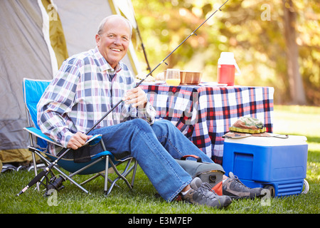 Senior Woman im Camping Urlaub mit Angelrute Stockfoto