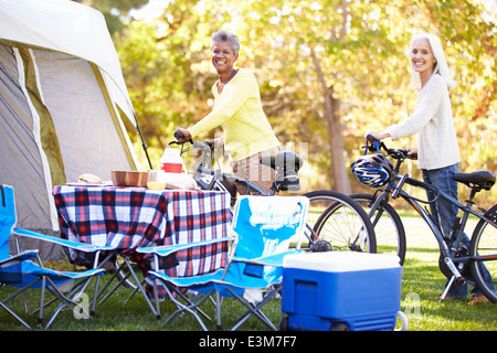 Zwei Reife Frauen Reiten Fahrräder auf Campingurlaub Stockfoto