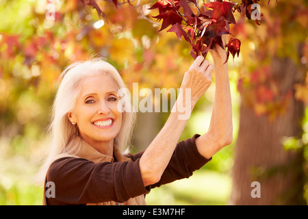 Reife Frau In Herbst Landschaft entspannen Stockfoto