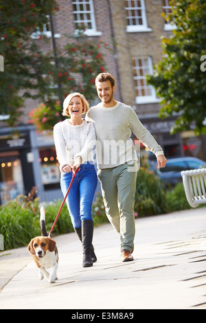 Paar mit Hund Spaziergang im Stadtpark Stockfoto