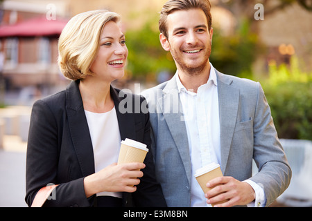 Business-paar zu Fuß durch den Park mit Kaffee zum mitnehmen Stockfoto