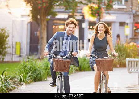 Geschäftsfrau und Geschäftsmann mit Fahrrad durch den Stadtpark Stockfoto