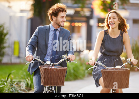 Geschäftsfrau und Geschäftsmann mit Fahrrad durch den Stadtpark Stockfoto
