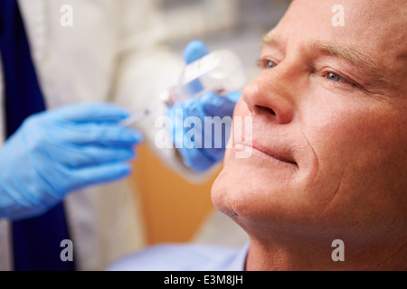 Mann mit Botox-Behandlung bei Beauty-Klinik Stockfoto