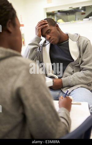 Mann im Gespräch mit der Beraterin, die Notizen macht Stockfoto