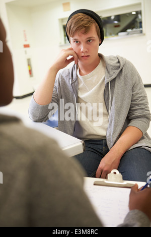 Junger Mann im Gespräch mit Berater, macht sich Notizen Stockfoto