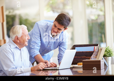 Teenager Enkel helfen Großvater mit Laptop Stockfoto