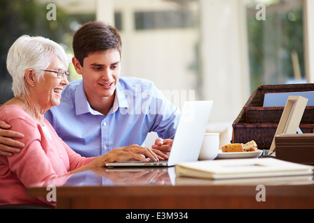Teenager Enkel helfen Großmutter mit Laptop Stockfoto