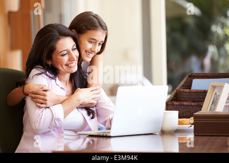 Mutter und Tochter im Teenageralter auf Laptop zusammen Stockfoto