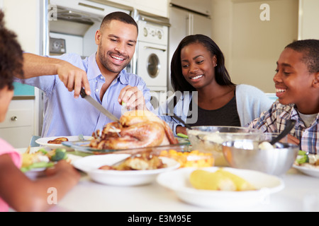 Familie sitzt an Tisch zu Hause essen Essen Stockfoto