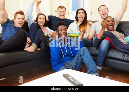 Gruppe von Freunden vor dem Fernseher zu Hause zusammen Stockfoto