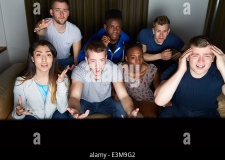 Gruppe von Freunden vor dem Fernseher zu Hause zusammen Stockfoto