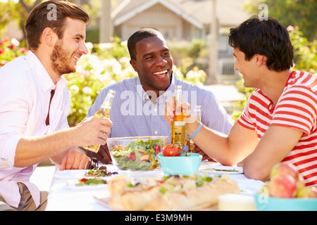 Drei männliche Freunde genießen Mahlzeit auf Outdoor-Party