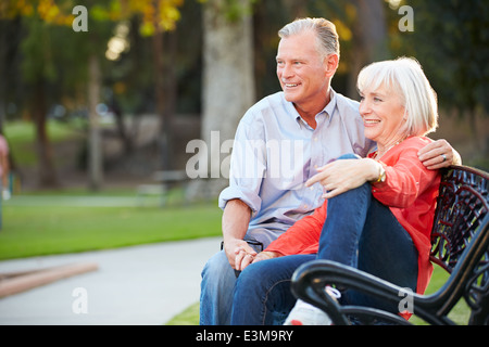 Reifen Sie romantisch zu zweit zusammen auf Parkbank sitzen Stockfoto