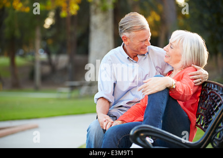 Reifen Sie romantisch zu zweit zusammen auf Parkbank sitzen Stockfoto