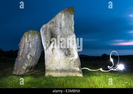 Zwei der Sarsen Steine beleuchtet bei Fackelschein in Avebury in Wiltshire - England Stockfoto