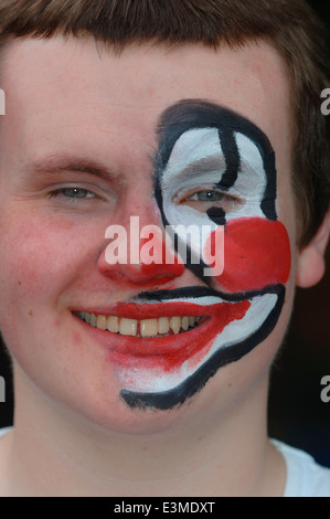 Teenager mit Hälfte seines Gesichts gemalt als Clown. Stockfoto