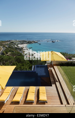 Blick auf Ozean jenseits von Luxus-Schwimmbad und Terrasse Stockfoto