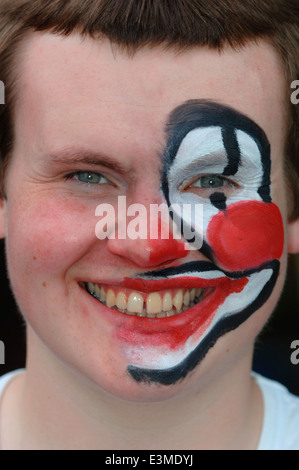 Teenager mit Hälfte seines Gesichts gemalt als Clown. Stockfoto