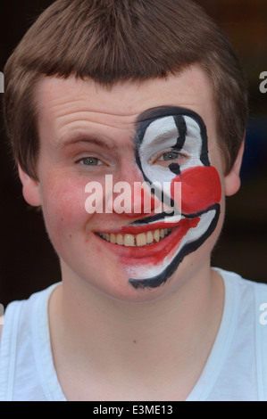 Teenager mit Hälfte seines Gesichts gemalt als Clown. Stockfoto