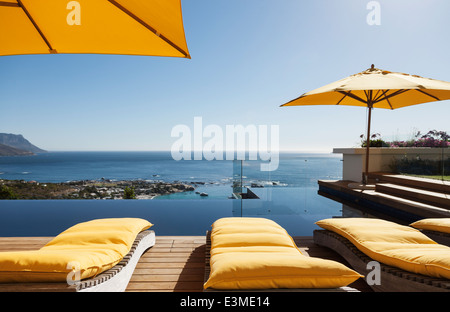 Sonnenliegen mit Blick auf Pool und Meer Stockfoto