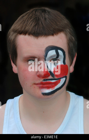 Teenager mit Hälfte seines Gesichts gemalt als Clown. Stockfoto