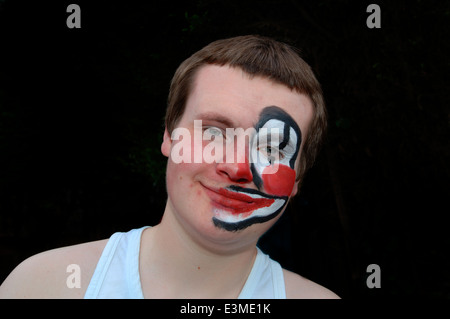 Teenager mit Hälfte seines Gesichts gemalt als Clown. Stockfoto