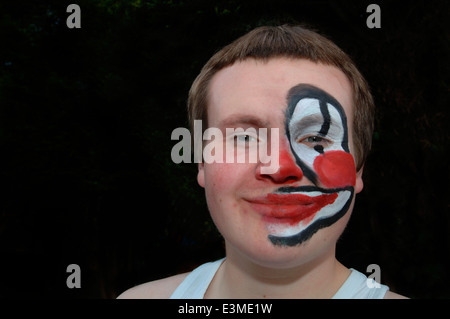 Teenager mit Hälfte seines Gesichts gemalt als Clown. Stockfoto