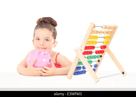 Kleines Mädchen zählen ihre Ersparnisse auf einem Abakus Stockfoto