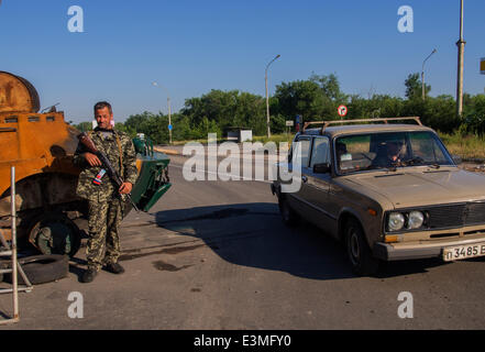 Oleksandrivs'k, Luhans'ka Oblast, Ukraine. 24. Juni 2014. Bewaffneten prorussischen Rebellen posiert vor dem Hintergrund der abgestürzten gepanzerten Nationalgarde der Ukraine am Checkpoint in der Oleksandrivs'k Stadt, Luhans'ka Oblast---wegen zahlreiche terroristische Angriffe auf die Position des ukrainischen Truppen, die 24. Juni 2014 von Mi-8 Hubschrauber, getroffen wurde neun ukrainische Militär zu töten. Als Folge dieses und andere terroristische Anschläge Präsident der Ukraine Petro Poroschenko nicht ausgeschlossen, dass ein Waffenstillstand vorzeitig abgebrochen werden kann. Bildnachweis: Igor Golovnov/Alamy Live-Nachrichten Stockfoto