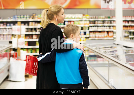 Rückansicht des Mutter und Sohn, die Lebensmittel im Supermarkt einkaufen Stockfoto