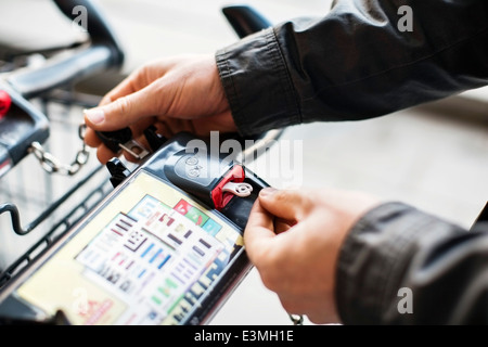 Beschnitten Menschenbild Einkaufswagen im Supermarkt Kette entfernen Stockfoto