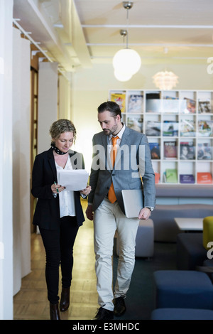 Reife Geschäftsfrau und Geschäftsmann mit Papierkram in Kreativbüro Stockfoto