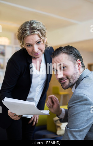 Porträt von zuversichtlich Geschäftsleute mit Papierkram im Büro Stockfoto