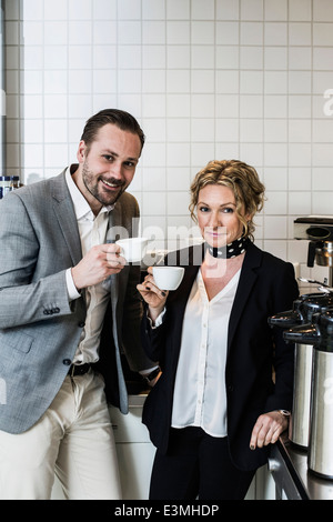 Porträt des Lächelns Geschäftsleute Kaffeetrinken in Küche Stockfoto