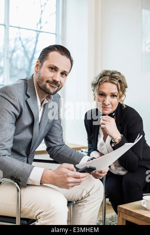 Porträt von zuversichtlich Geschäftsleute mit Papierkram im Büro Stockfoto