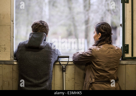 Rückansicht des jungen Paares Blick durch Fenster der Pferdestall Stockfoto