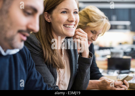 Lächelnd Geschäftsfrau wegschauen im Büro treffen Stockfoto