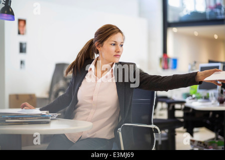Geschäftsfrau Einnahme Dokument am Schreibtisch im Büro Stockfoto
