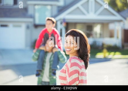 Portrait von lächelnden Frau mit Familie auf der Straße Stockfoto