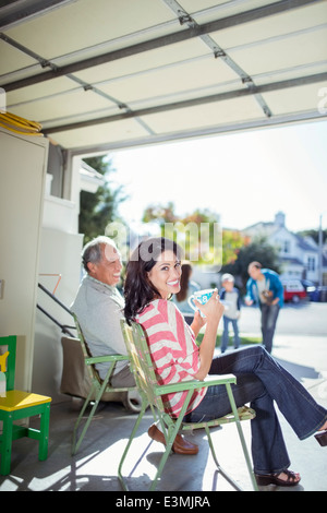 Porträt der lächelnde Frau Kaffeetrinken in garage Stockfoto