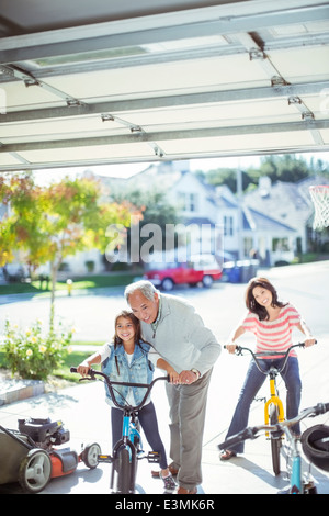 Mehr-Generationen-Familie auf Fahrrädern in Einfahrt Stockfoto