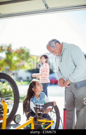 Großvater und Enkelin aufblasen Fahrrad Reifen Stockfoto