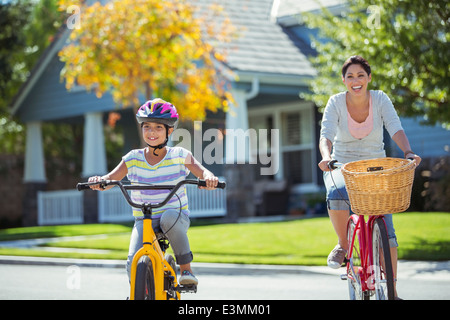 Mutter und Tochter auf Fahrrädern in sonnige Straße Stockfoto