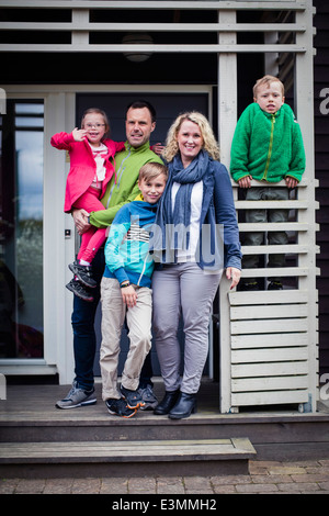 Porträt der glücklichen Familie stehen bei Veranda Stockfoto