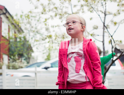 Nachdenklich Mädchen mit Down-Syndrom wegsehen stehend in Rasen Stockfoto