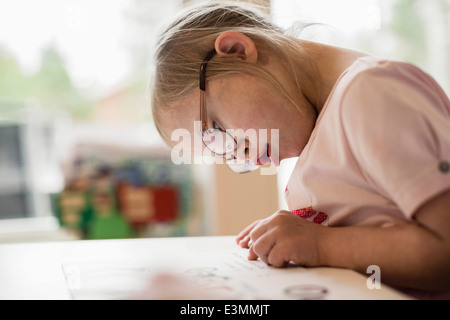 Mädchen mit Down-Syndrom lernen am Tisch Stockfoto