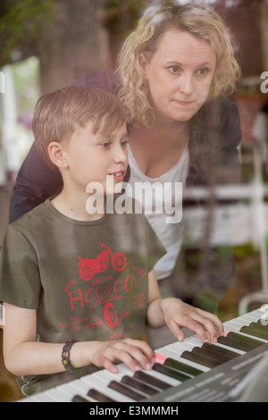 Mutter, Lehre Klavier Sohn im Haus Stockfoto