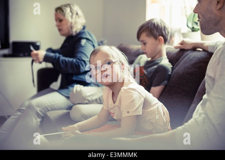 Porträt von Behinderten Mädchen sitzen mit der Familie zu Hause auf sofa Stockfoto