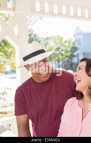 Paar lachend auf sonnige Veranda Stockfoto